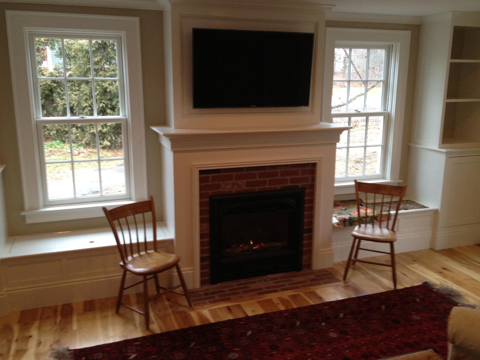 Traditional living room with a brick fireplace and built-in shelves, designed by Oxland Builders in New Hampshire