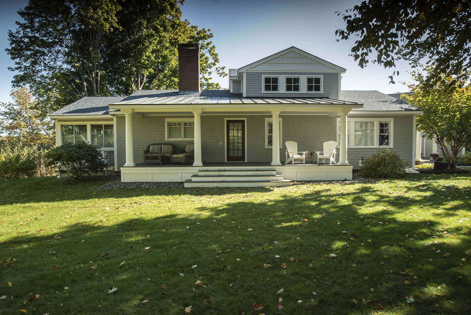 Coastal-style home with a covered porch and classic architectural details, built by Oxland Builders in New Hampshire
